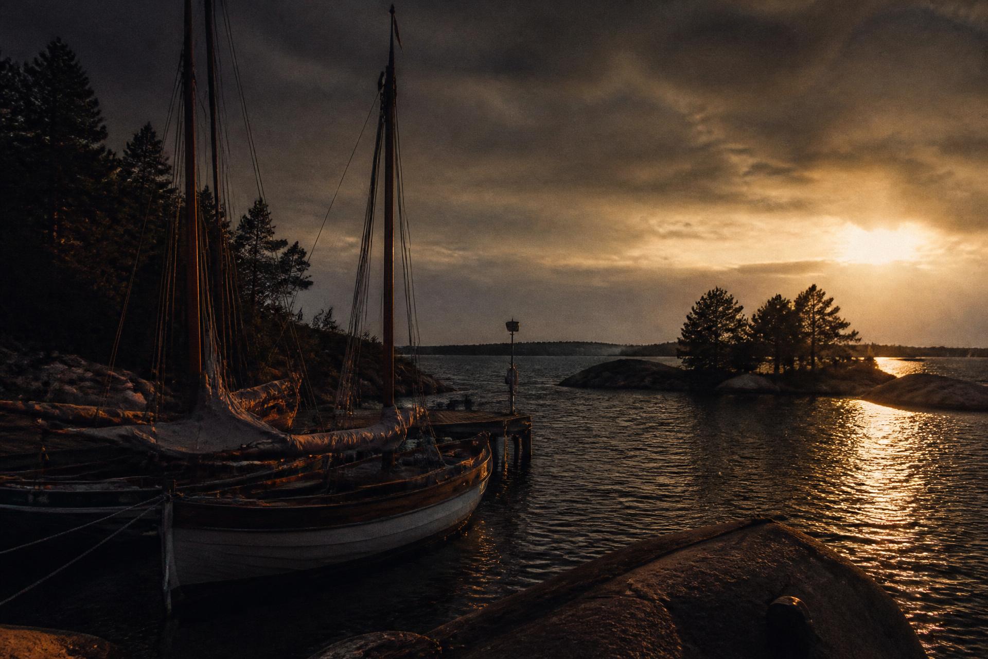 Wooden sailboats moored in the Finnish archipelago at dusk